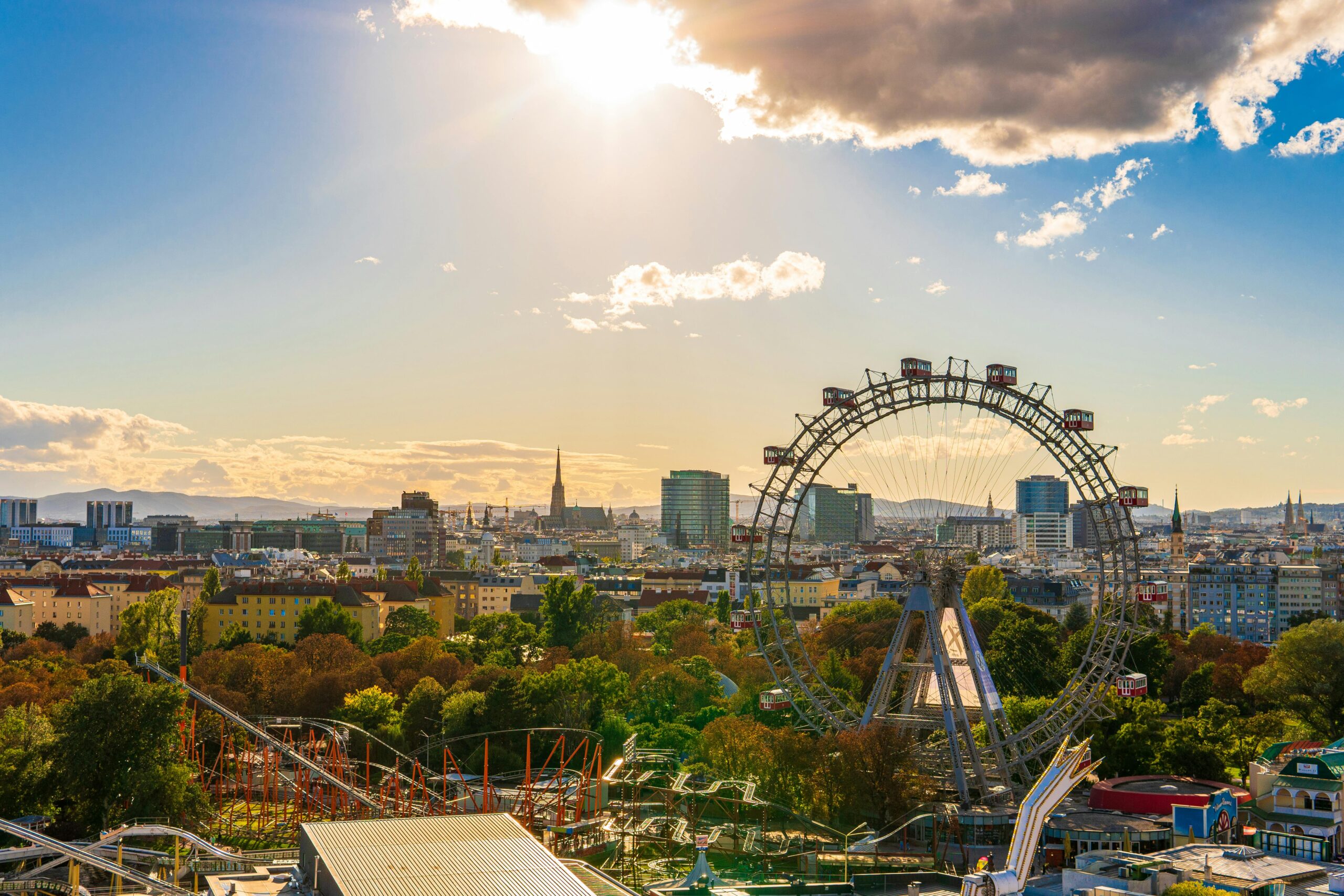 Luftaufnahme des Wiener Praters mit dem Riesenrad im Vordergrund, unter einem strahlenden Himmel – ein perfekter Tag, um mit dem Vorteilsclub der Stadt Wien die Escape-Rooms von Time-Busters zu entdecken.