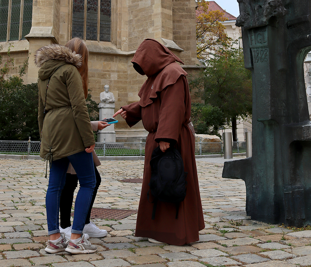Outdoor Exit Game von Time-Busters Wien: Zwei Kinder und ein Mönch, der Hinweise gibt