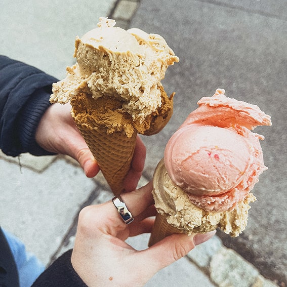 Zwei Hände die ein Stanitzel mit zwei Eiskugeln hält von Anton's Tafel in Wien